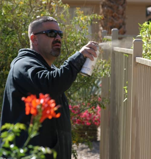 touching up iron fence with spray paint